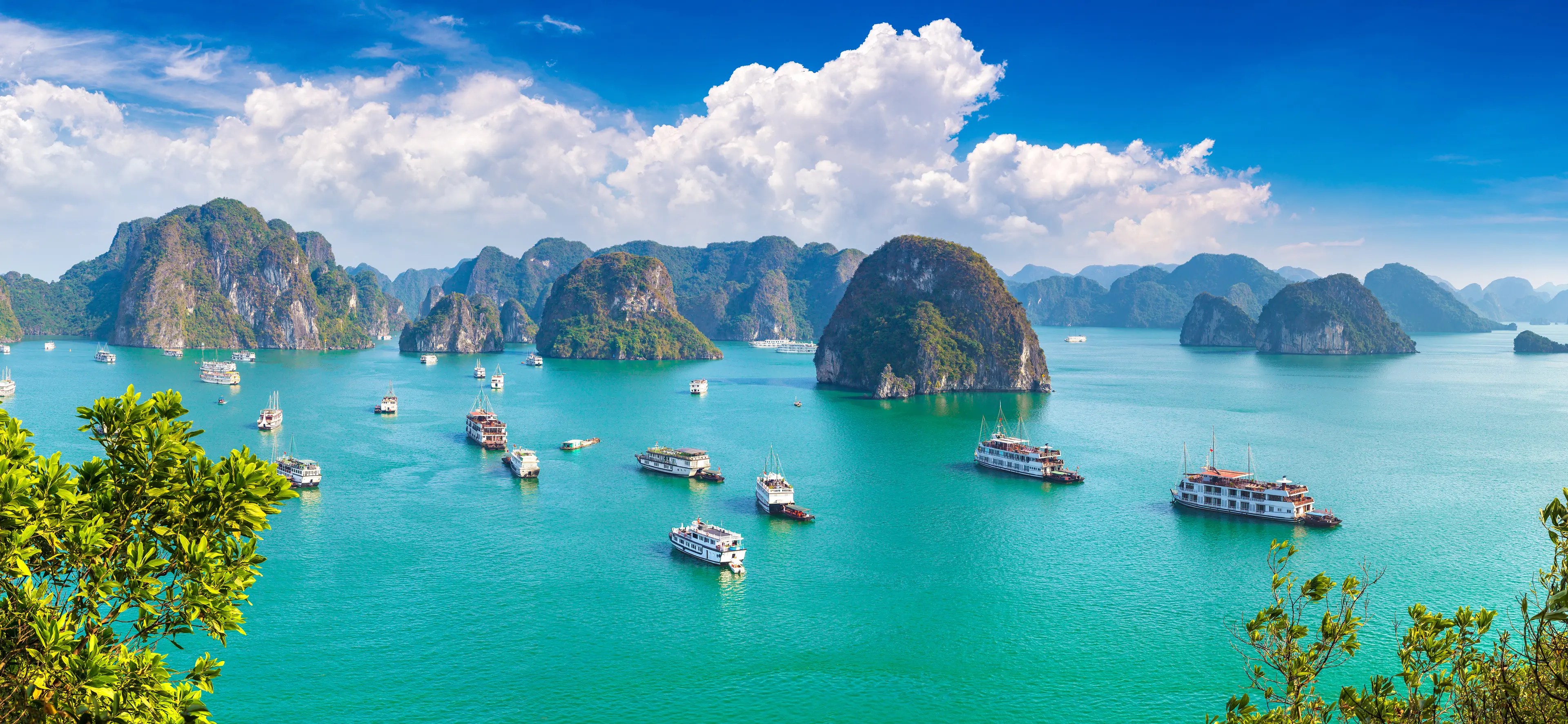 Aerial view of the Ha Long Bay area with tourist vessels spread around the waters