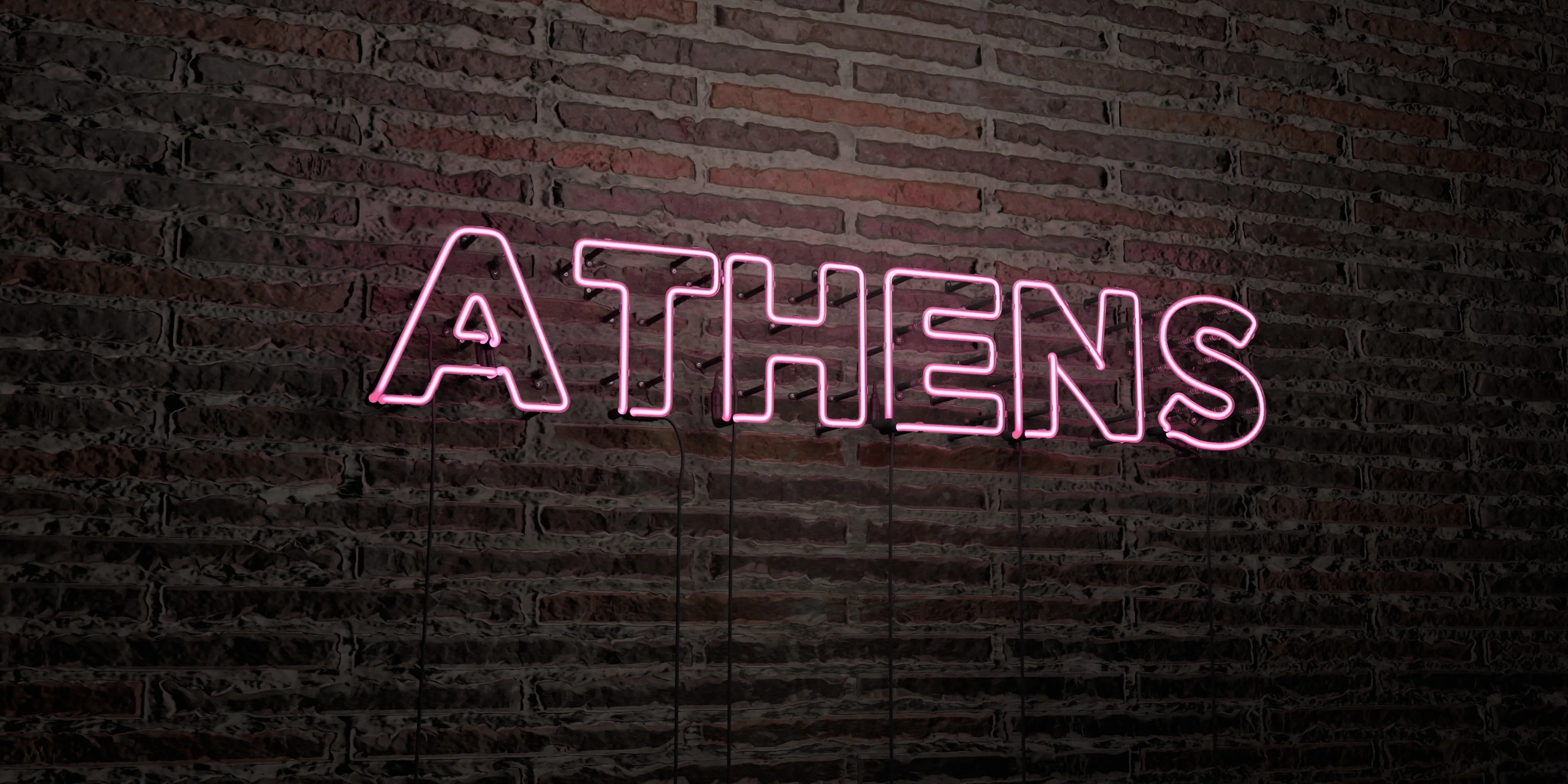 A neon pink sign forming the word Athens against a brick wall.