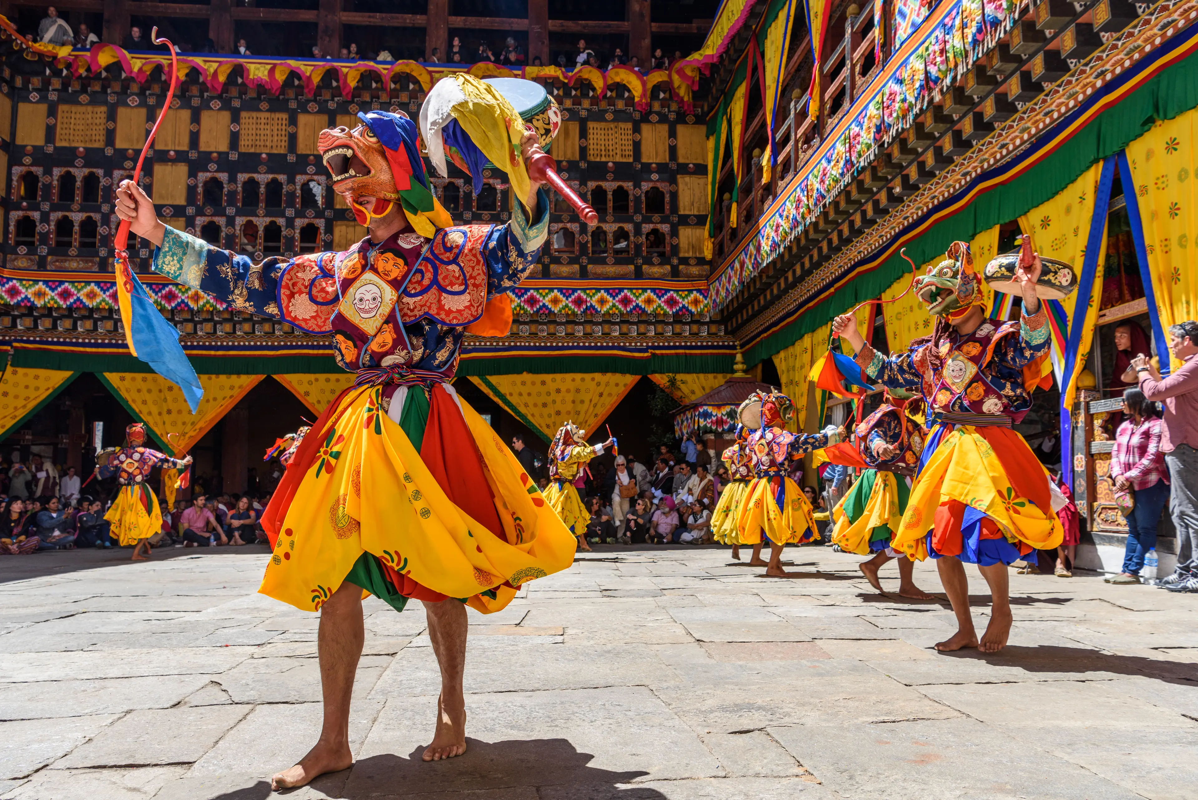 Buddhist monk dancing wearing a colorful mask at the Paro Tsechu festival 