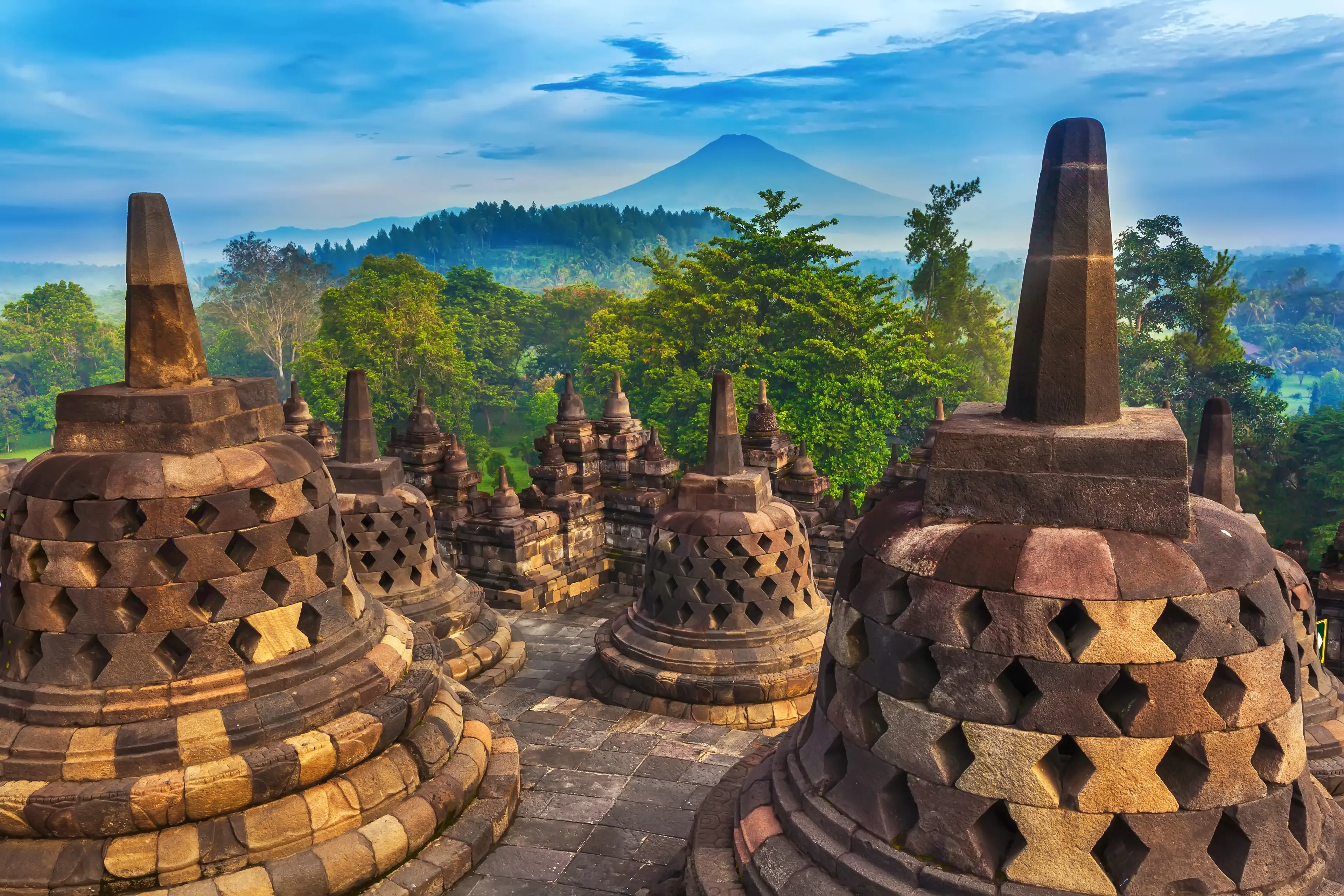 Candi Borobudur in the background of rainforest and Sumbing Mountain.