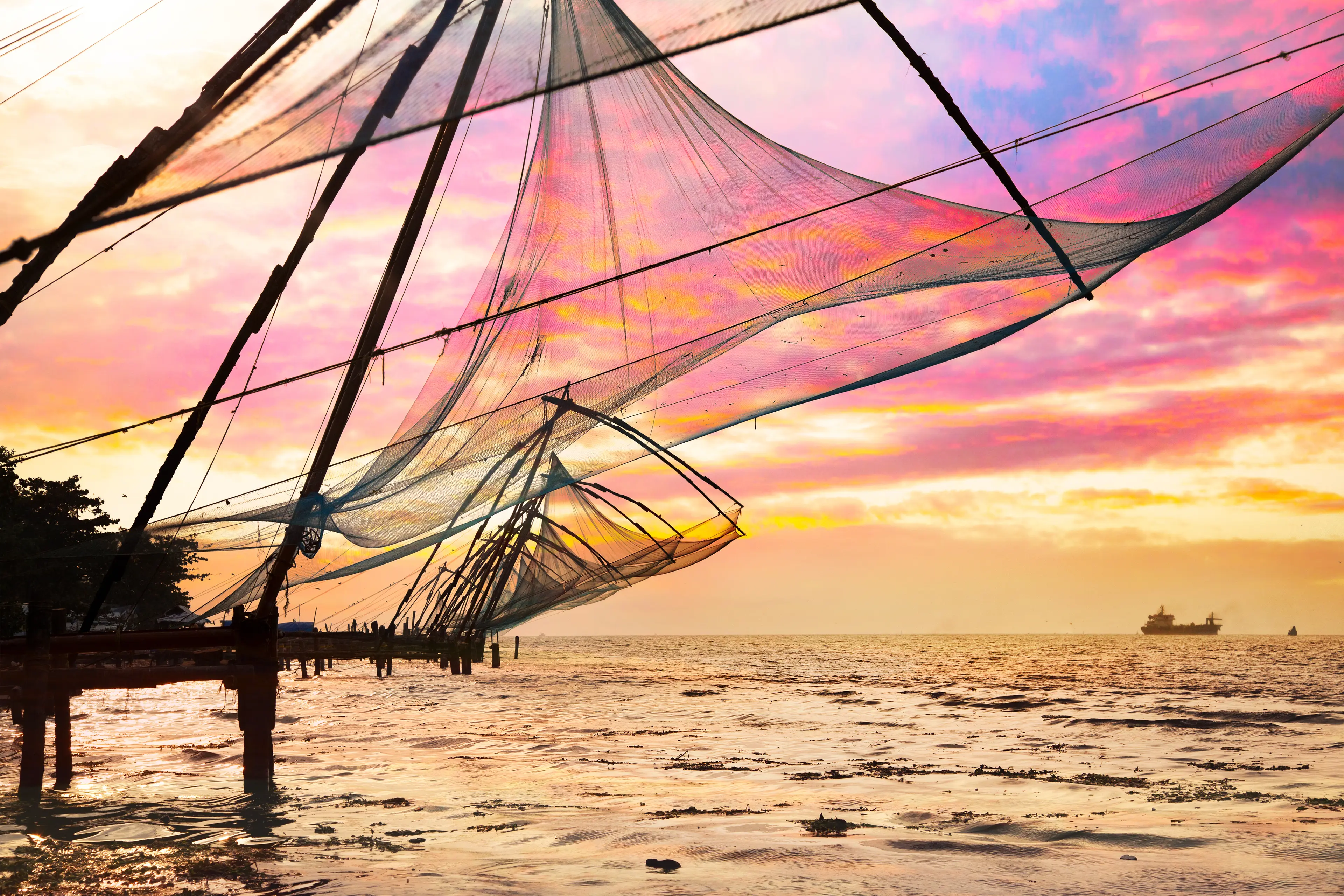 Chinese fishing nets outside the water at sunset Chinese fishing nets outside the water at sunset