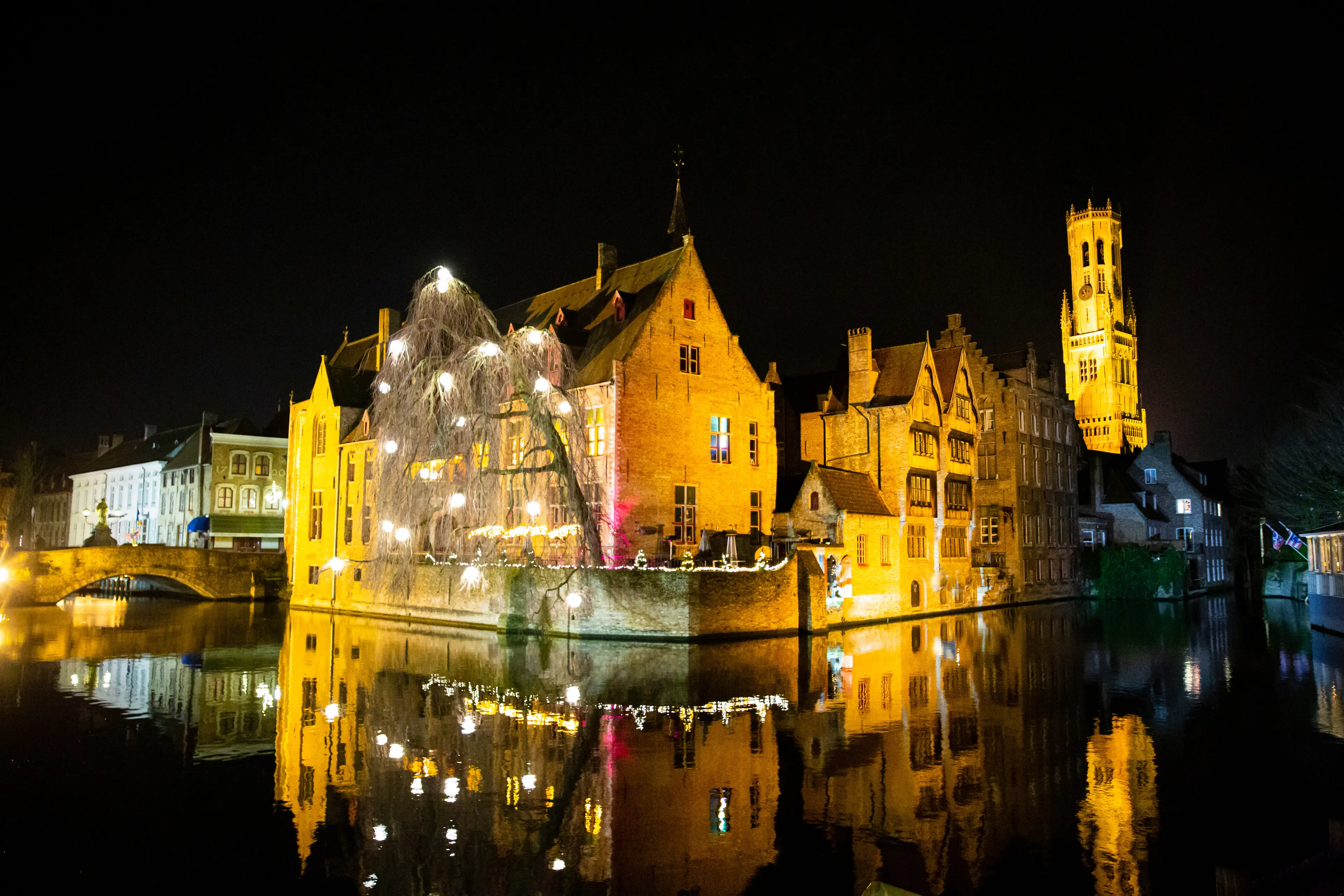 Old medieval buildings reflect in the water at Christmas.