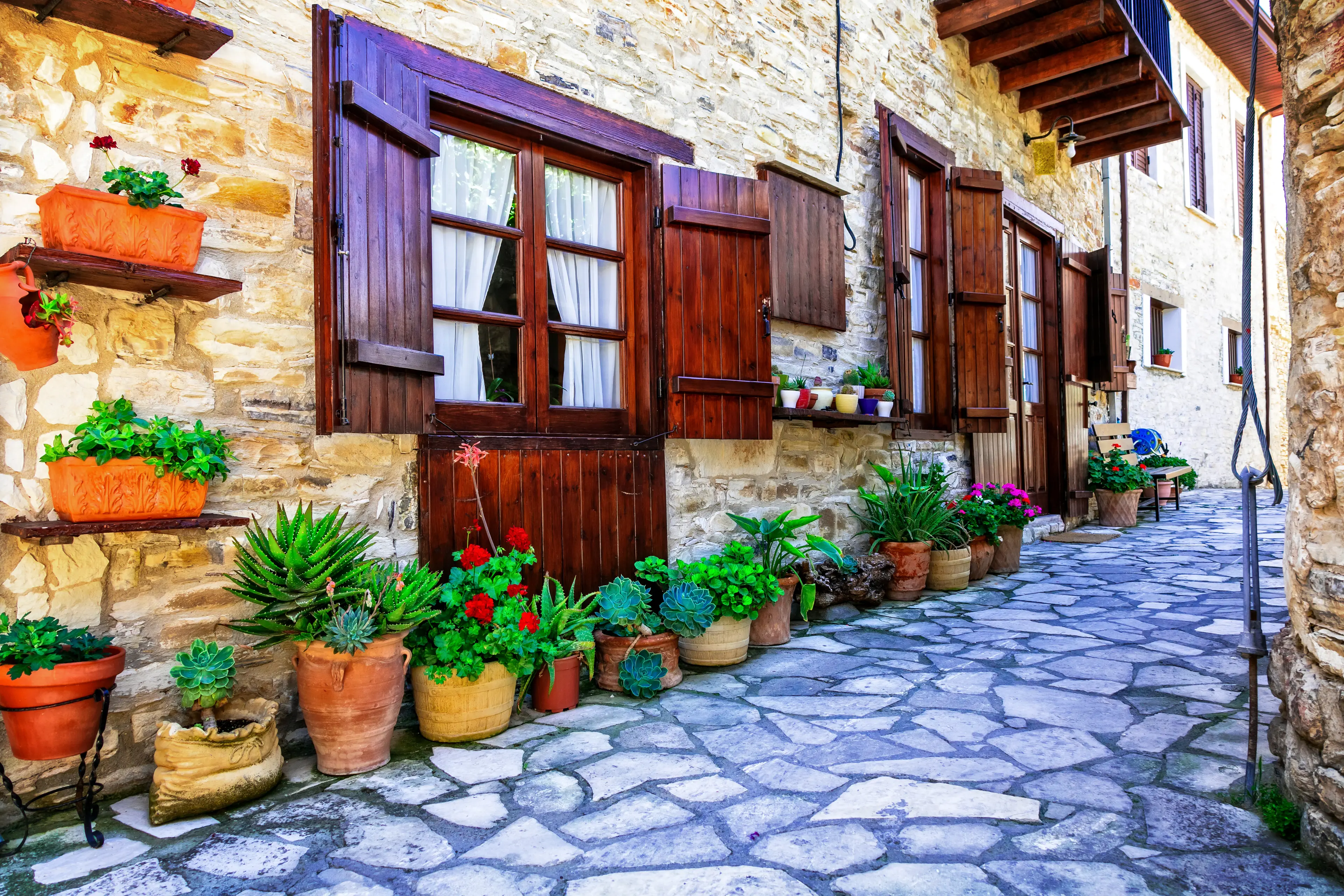 Pots with plants lined up outside a traditional stone house in Lefkara