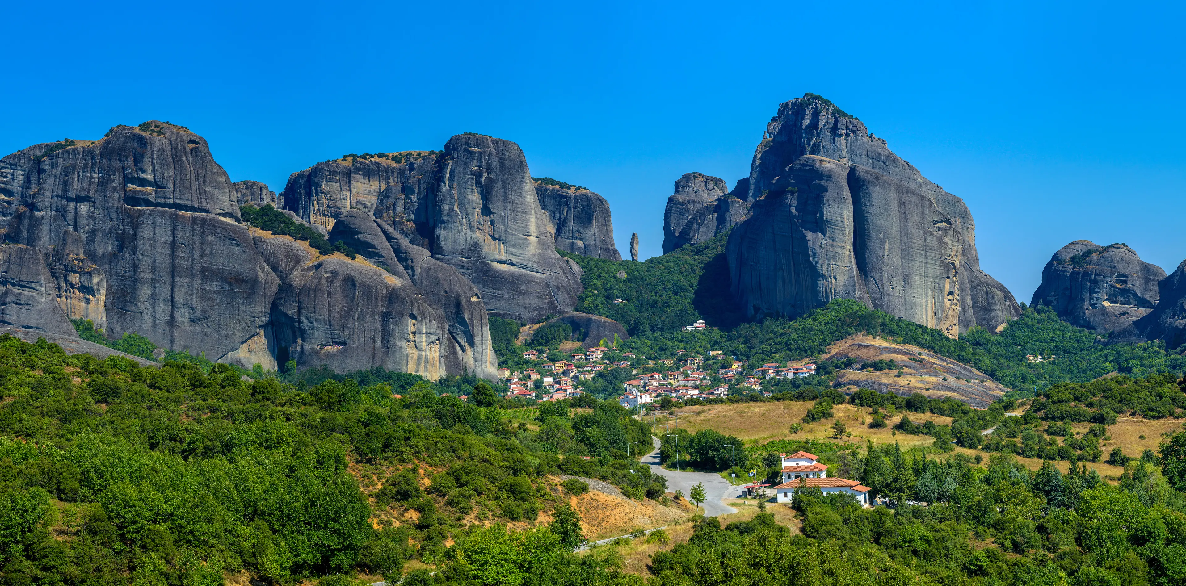 The rock formations of Meteora rising behind the town