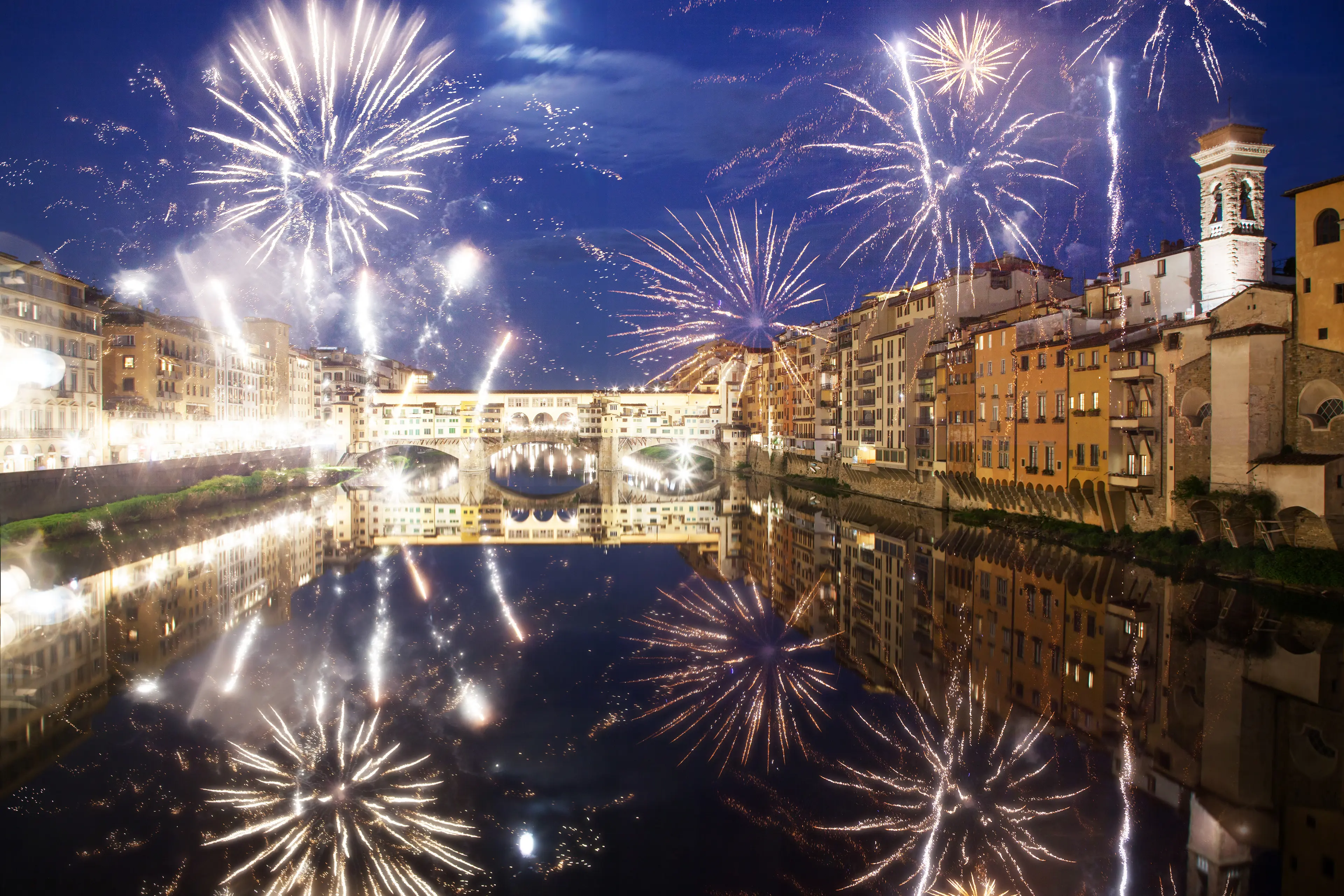 Celebrating New year's eve, fireworks around ponte vecchio on river arno