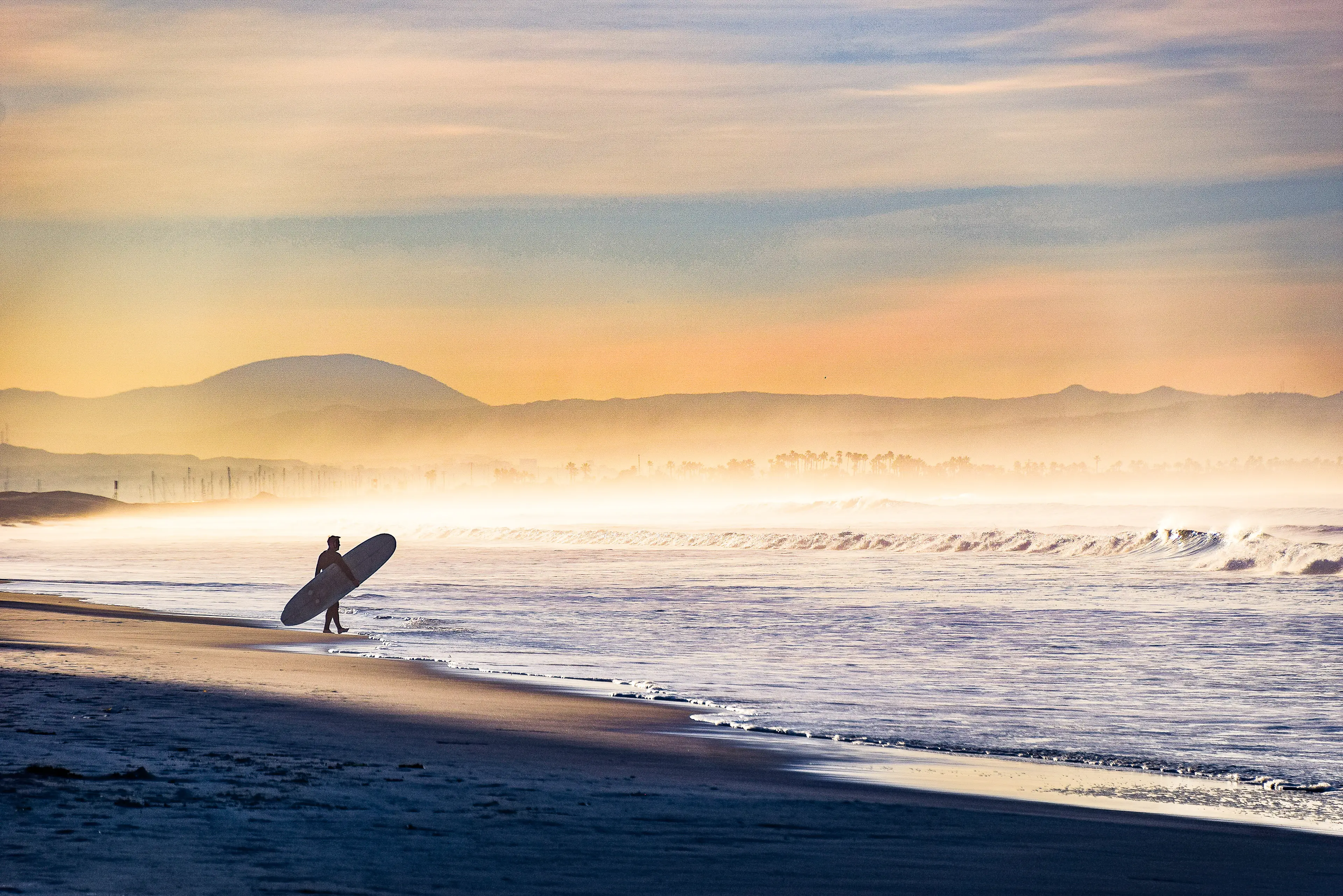 Surfer entering the surf in the early morning