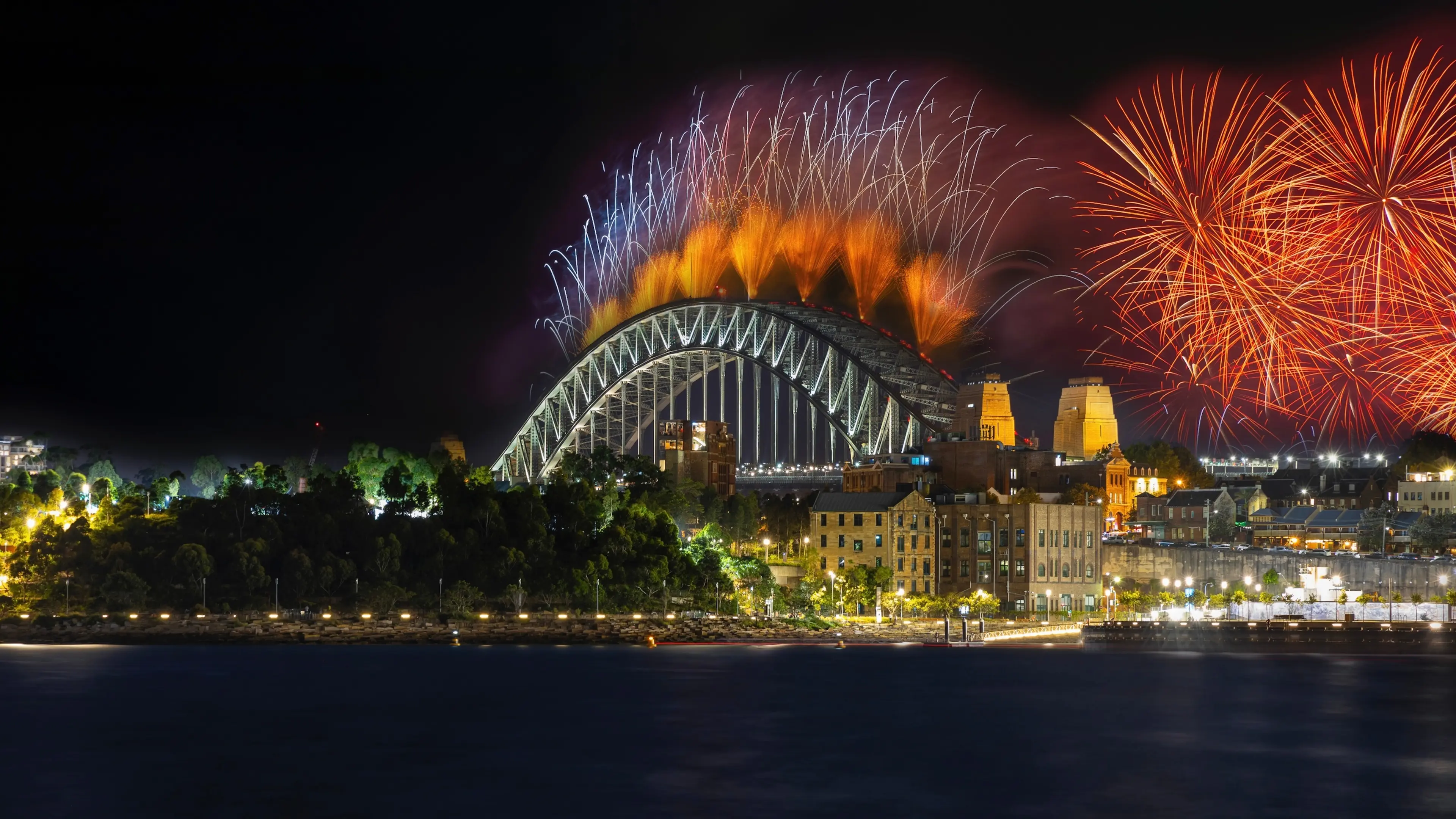 City harbour bridge illuminated with vivid colours from New Years Eve fireworks
