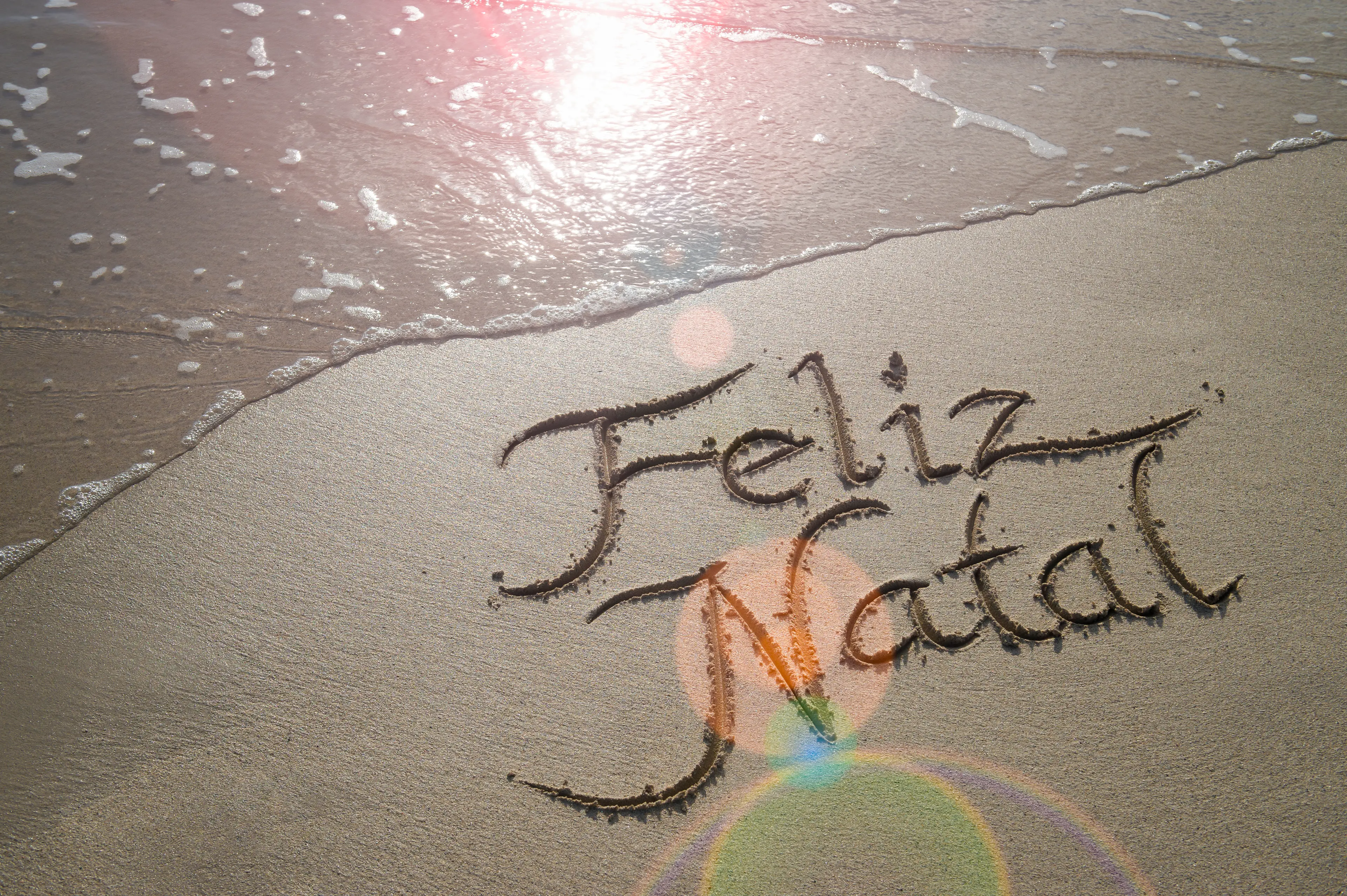 Feliz Natal handwritten in the sand in Rio de Janeiro