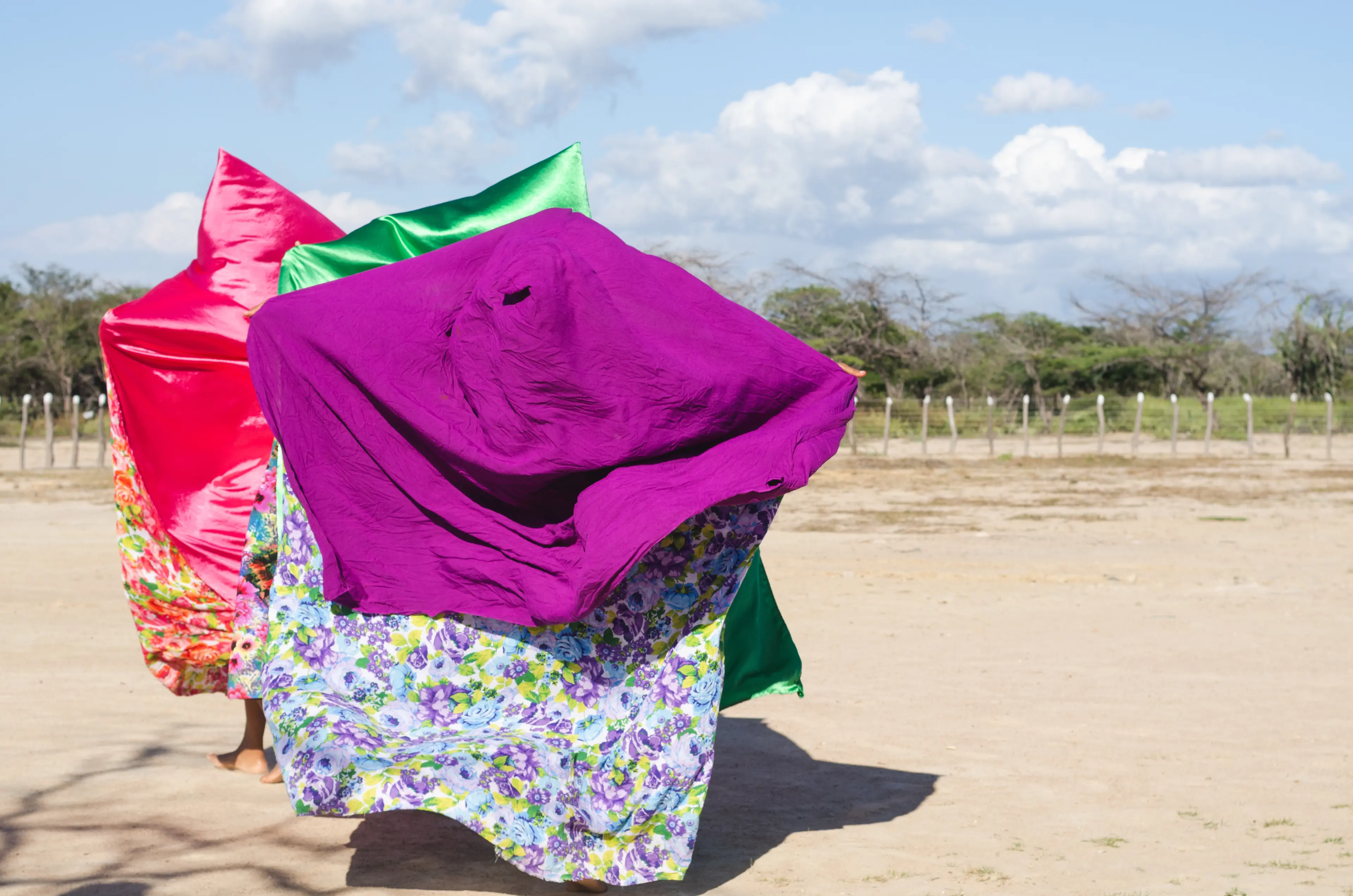 Three women with colorful capes dancing typical Wayuu dance. Indigenous culture of La Guajira